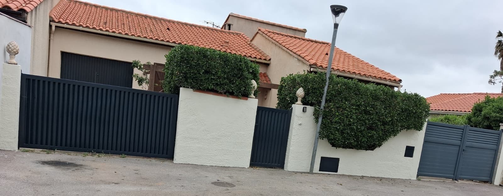 Mur de clôture rénové et repeint devant une maison